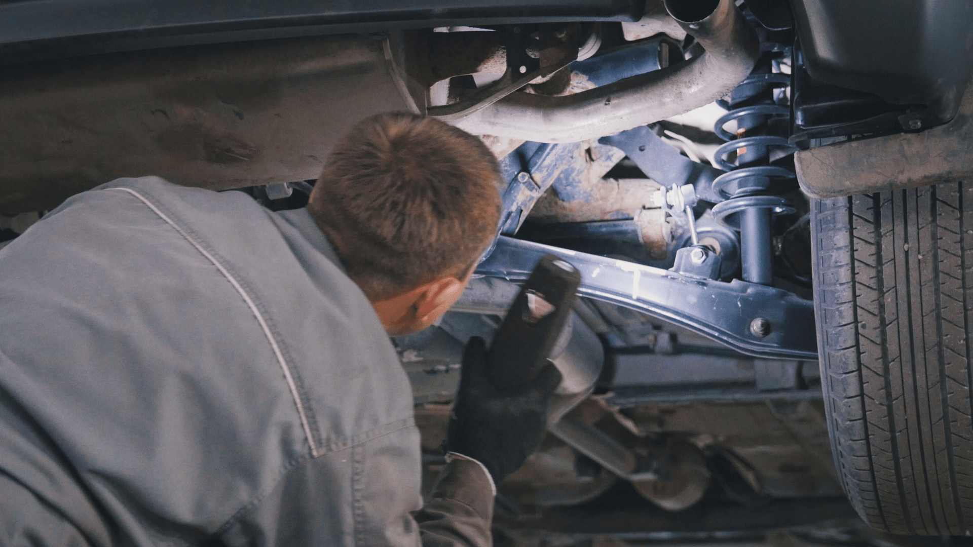 Delphi Technologies Expert using a torch to investigate the suspension of a car.