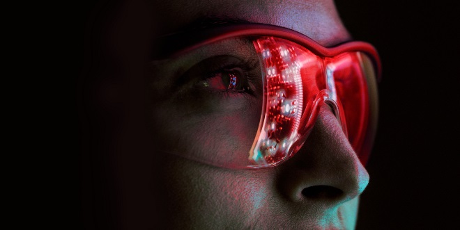 A person wearing red future-looking glasses